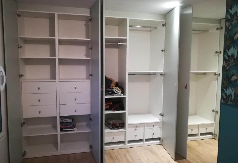 Pour une chambre à Hagetmau, agencement intérieur d’un dressing blanc avec étagères, tiroirs, penderies et porte miroir