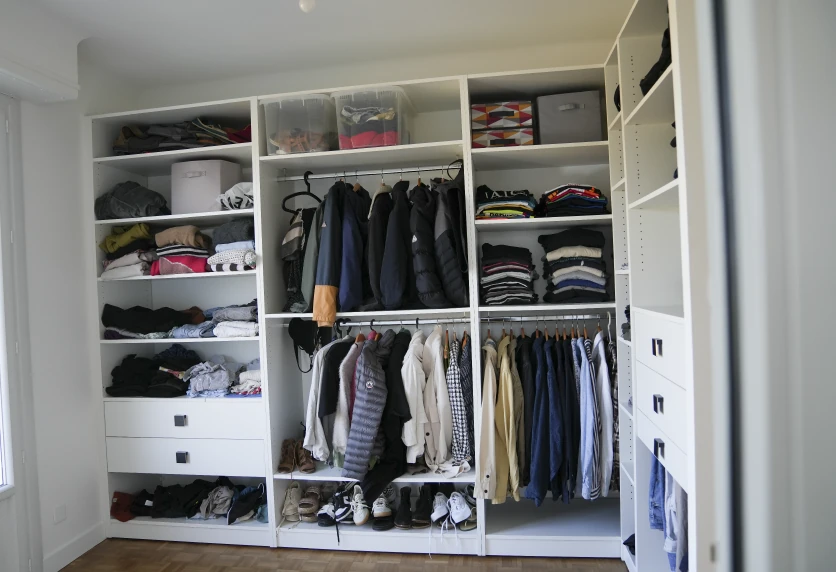 Dressing blanc ouvert avec deux niveaux de penderie et des rangements pour vêtements, dans un projet d’agencement intérieur à Audignon
