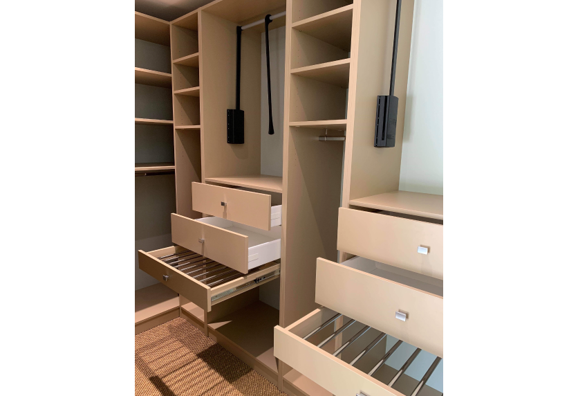 À Serres-Gaston, agencement intérieur d’un dressing en bois clair avec tiroirs ouverts et paniers coulissants
