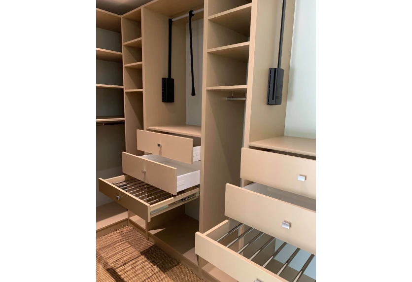 À Serres-Gaston, agencement intérieur d’un dressing en bois clair avec tiroirs ouverts et paniers coulissants