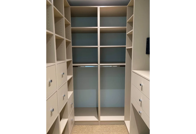 Étagères et tiroirs blancs disposés sur trois côtés d’un dressing, pour un agencement intérieur à Samadet
