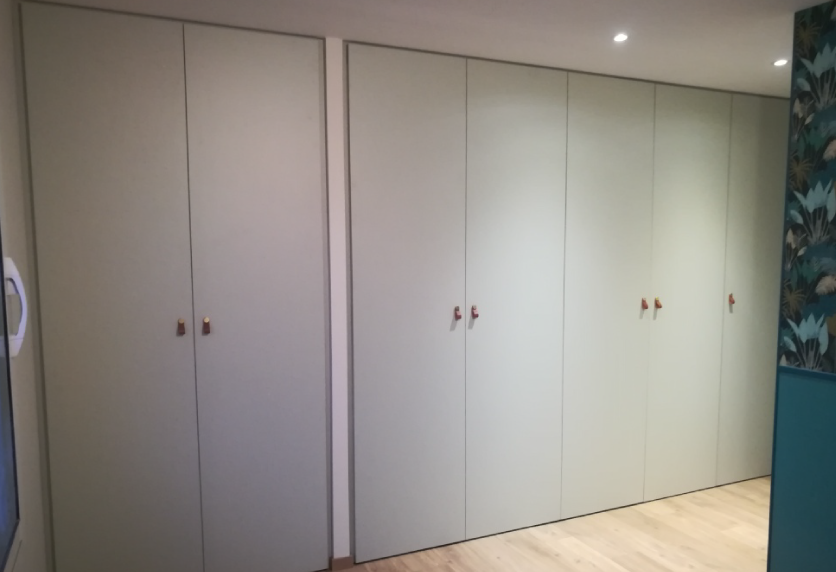 Pour une chambre à Castelnau-Tursan, agencement intérieur avec placards blancs toute hauteur aux portes fermées