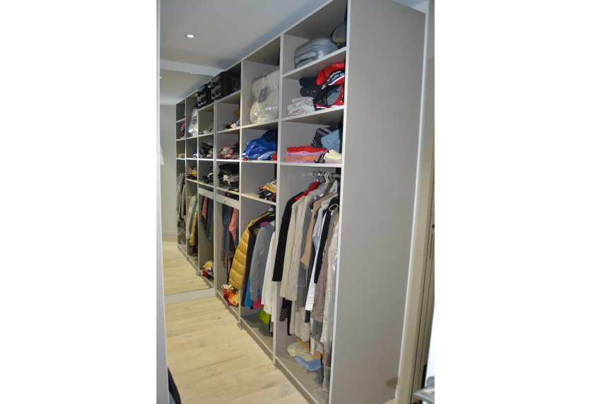 À Geaune, dressing ouvert avec longues penderies et étagères superposées dans un agencement intérieur