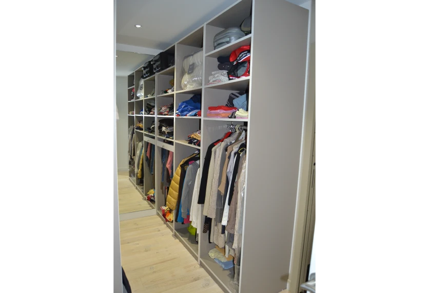 À Geaune, dressing ouvert avec longues penderies et étagères superposées dans un agencement intérieur