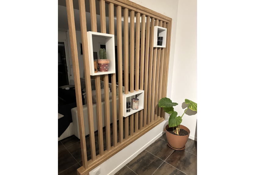 Pour une maison à Pimbo, agencement intérieur avec cloison à tasseaux de bois et niches de rangement
