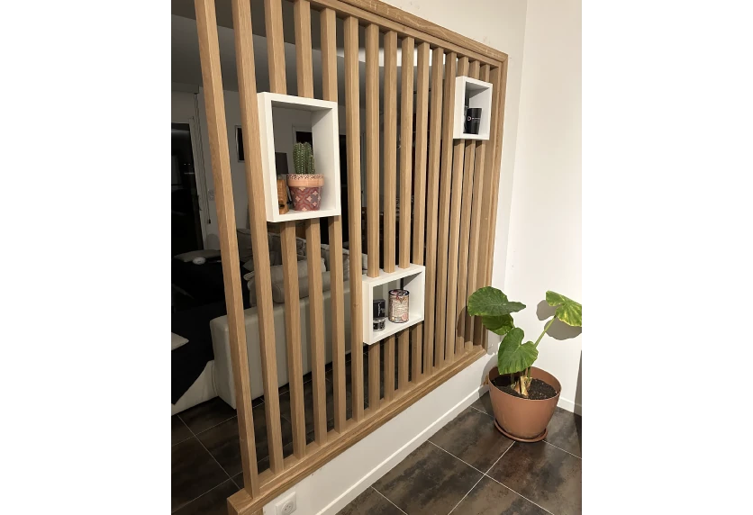 Pour une maison à Pimbo, agencement intérieur avec cloison à tasseaux de bois et niches de rangement