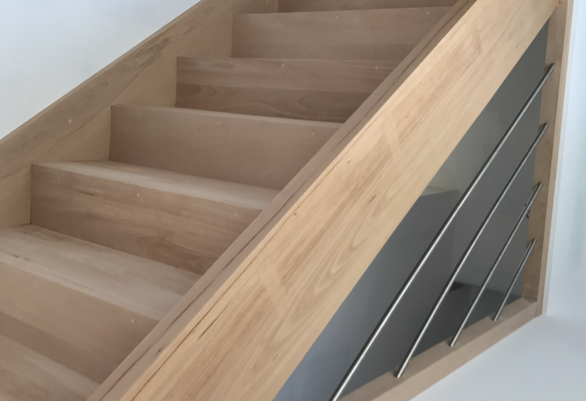 Escalier en bois clair avec garde-corps à câbles métalliques, détail d’agencement intérieur pour Lauret