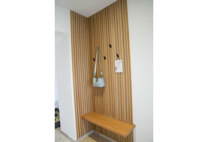 À Pécorade, agencement intérieur d’une entrée avec tasseaux verticaux, patères et banc en bois