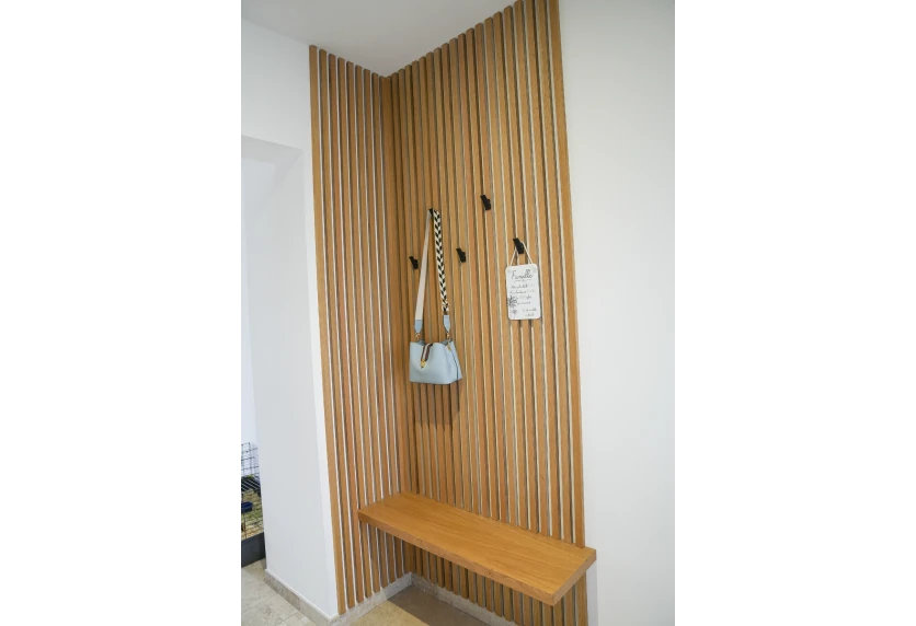 À Pécorade, agencement intérieur d’une entrée avec tasseaux verticaux, patères et banc en bois