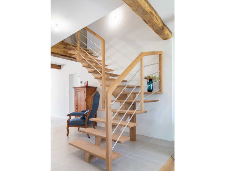 Escalier en bois à limon central sous une poutre apparente, dans un projet d’agencement intérieur à Bats