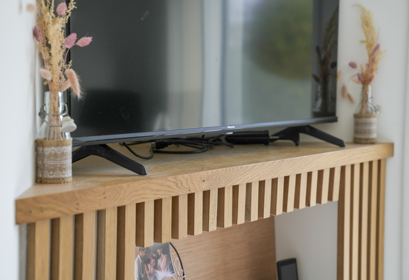 Meuble TV en bois à façade ajourée, détail d’un agencement intérieur pour un salon à Audignon