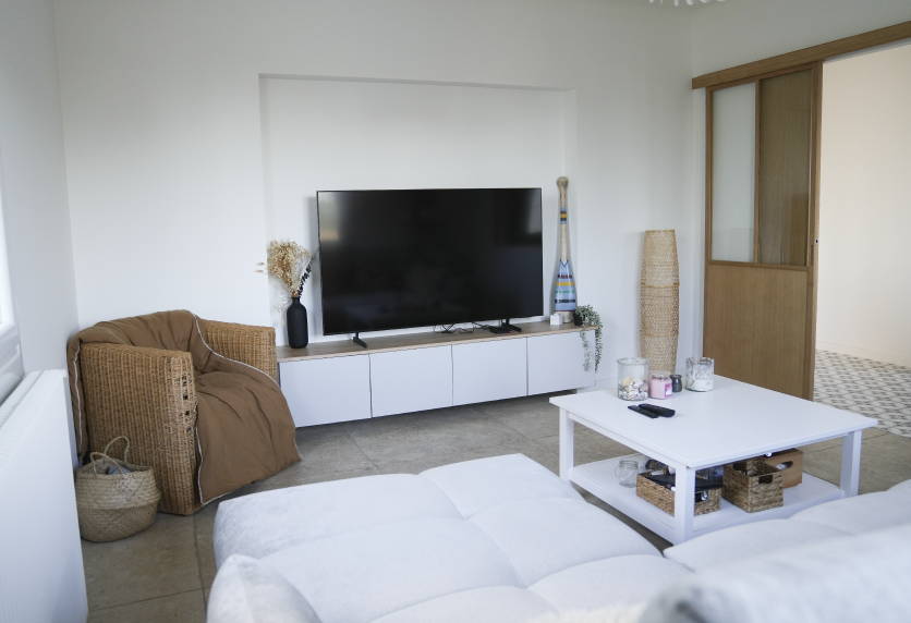Pour une pièce de vie à Serres-Gaston, agencement intérieur avec meuble TV blanc suspendu et rangements bas