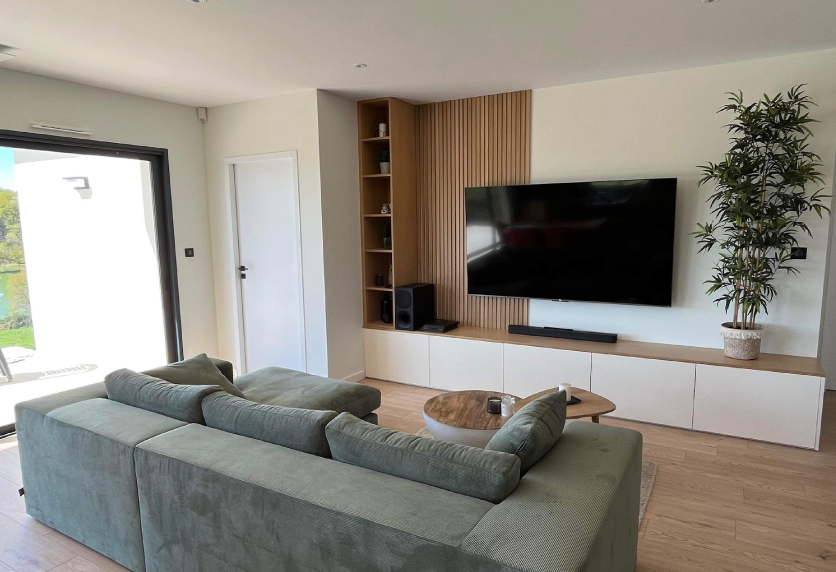 Agencement intérieur d’un salon à Castelnau-Tursan, avec mur TV à tasseaux verticaux et meuble bas blanc