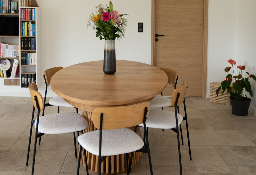 Dans la salle à manger d’une maison à Geaune, table ronde en bois au pied ajouré pour l’agencement intérieur