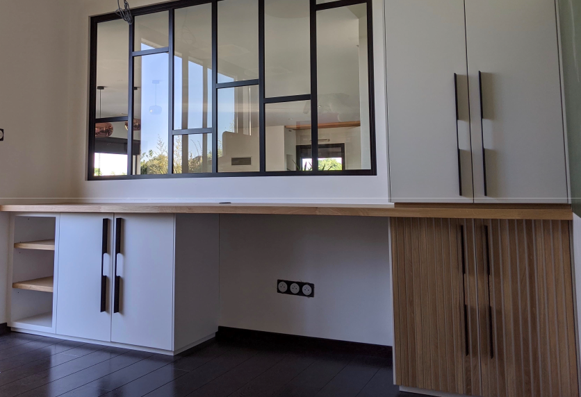 Sous une verrière à Clèdes, long bureau avec rangements blancs et bois dans un agencement intérieur