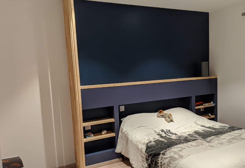 Pour une chambre à Lauret, tête de lit bleu foncé avec étagère en bois et niches latérales dans l’agencement intérieur