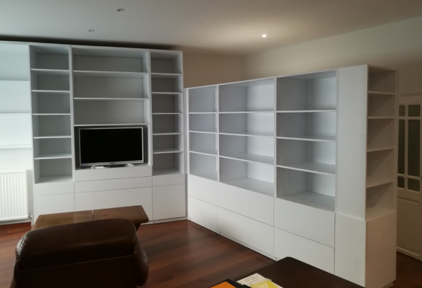 Bibliothèque blanche d’angle avec emplacement pour télévision, conçue pour un agencement intérieur à Pécorade