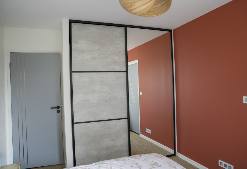 Placard de chambre à portes coulissantes et panneau miroir, conçu pour un agencement intérieur à Clèdes