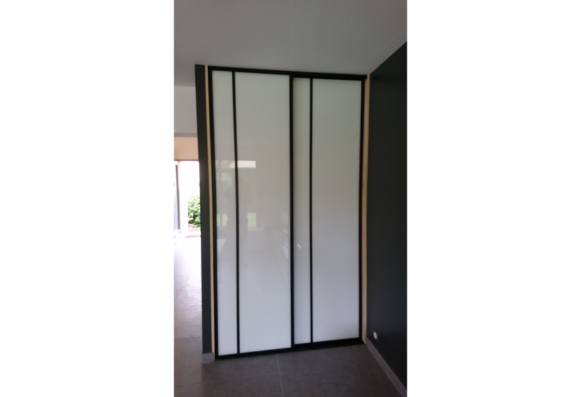 À Sorbets, portes coulissantes blanches à cadres noirs pour séparer les espaces dans un agencement intérieur