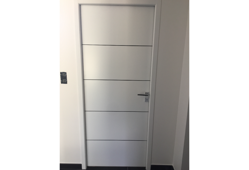 Dans une pièce à Geaune, porte blanche à rainures horizontales choisie pour l’agencement intérieur
