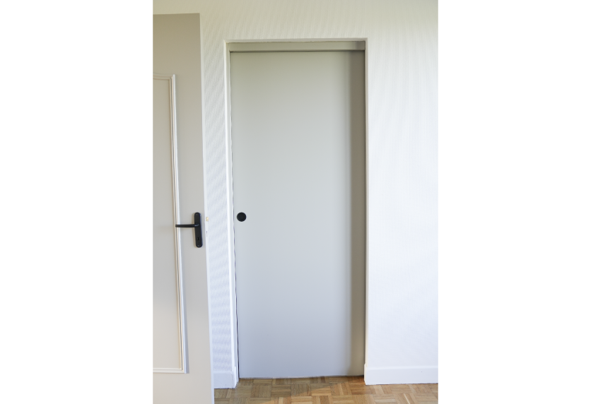Pour un espace à Pimbo, agencement intérieur avec porte coulissante blanche intégrée à la cloison