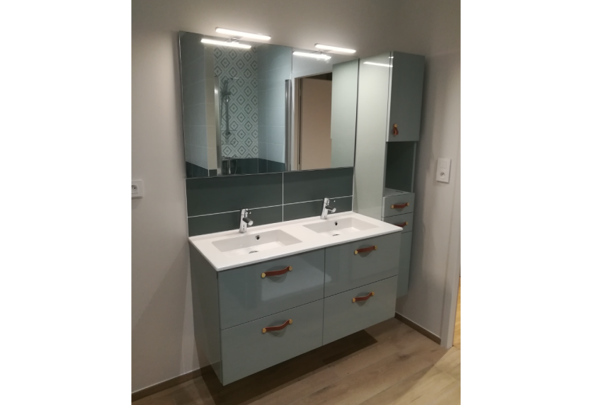 Agencement intérieur d’une salle de bain à Pimbo avec meuble bleu gris à double vasque et armoires miroir
