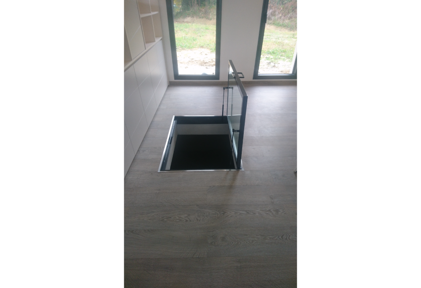 À Pimbo, une trappe de sol vitrée au-dessus de l’escalier apporte de la lumière à cet agencement intérieur.