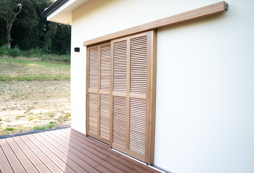 Portes coulissantes à persiennes en bois réalisées en menuiserie pour une terrasse à Serres-Castet