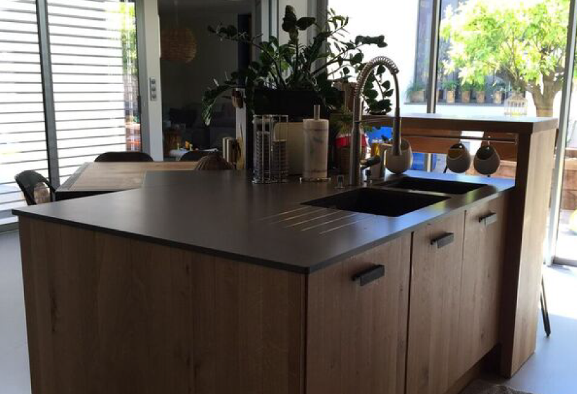 Îlot de cuisine en bois avec évier intégré et plan de travail foncé, pour un intérieur à Samadet