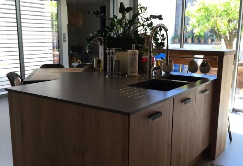 Îlot de cuisine en bois avec évier intégré et plan de travail foncé, pour un intérieur à Samadet