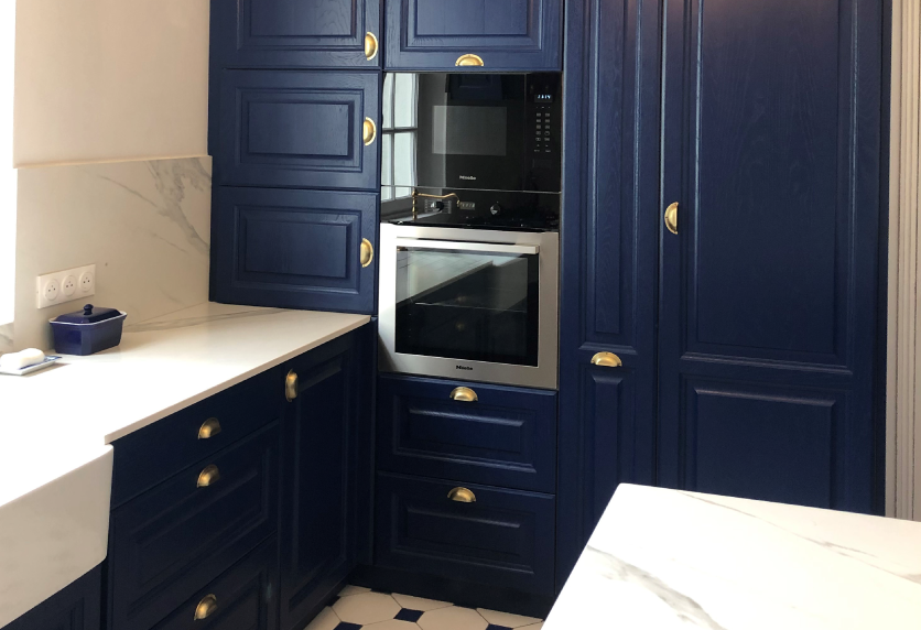 Cuisine bleu marine à Miramont-Sensacq, avec colonnes de rangement, four encastré et plan de travail clair