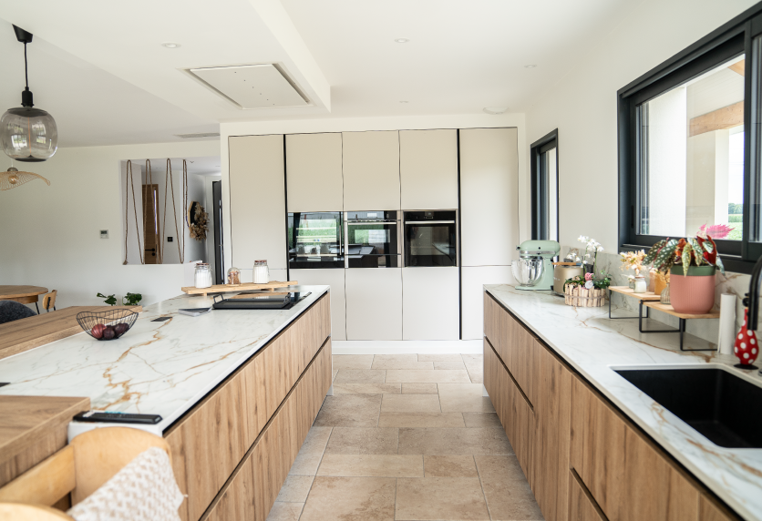 Cuisine avec îlot central en bois et plans de travail clairs, pour un intérieur à Samadet