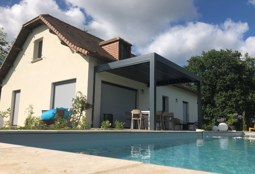 Vue depuis la piscine sur une pergola anthracite adossée à la maison, pour une réalisation de menuiserie à Boueilh-Boueilho-Lasque.