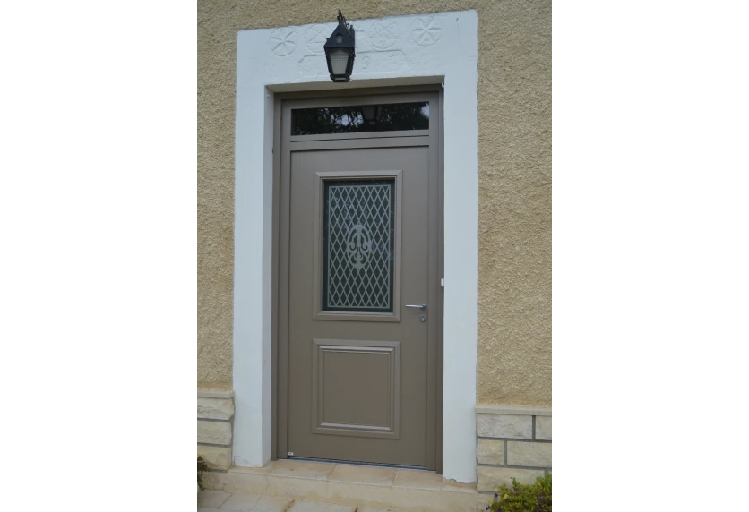 À Serres-Castet, porte d’entrée gris taupe avec vitrage à motifs et imposte vitrée, dans un projet de menuiserie
