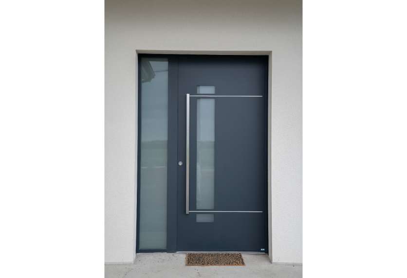 À Viven, menuiserie de porte d’entrée anthracite avec vitrage vertical, panneau latéral vitré et décor géométrique