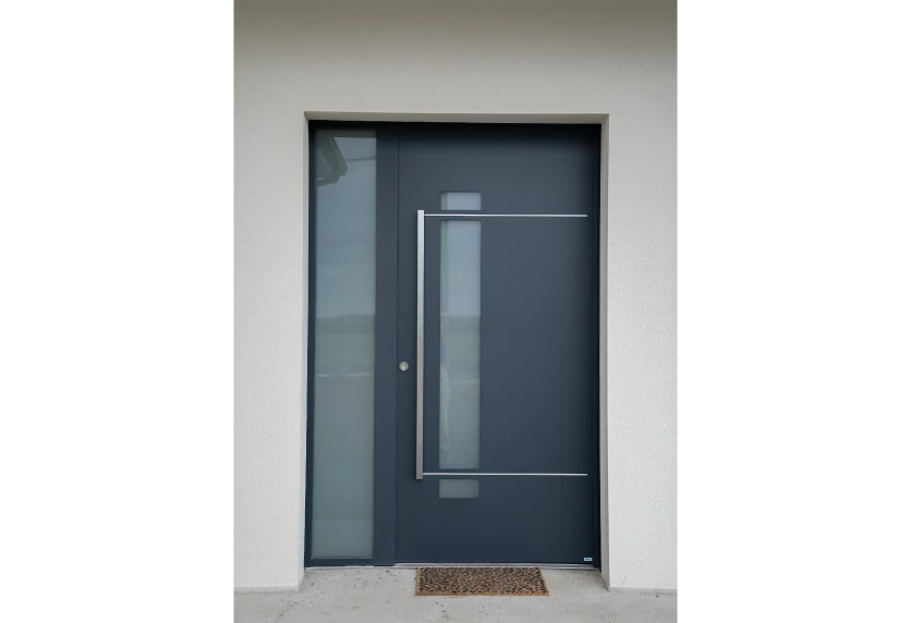 À Viven, menuiserie de porte d’entrée anthracite avec vitrage vertical, panneau latéral vitré et décor géométrique