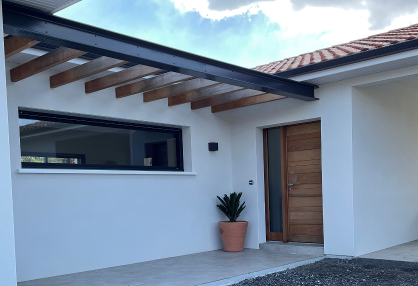 Fenêtre horizontale aux profilés foncés sous un auvent, une menuiserie adaptée à une entrée de maison à Miossens-Lanusse
