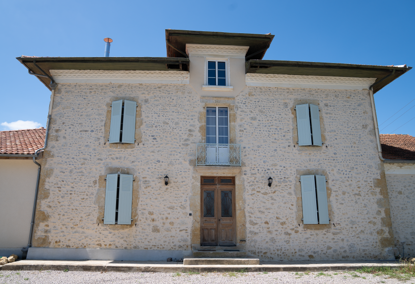 Volets battants bleu clair sur la façade d’une maison en pierre, un modèle de menuiserie pour un projet à Pau