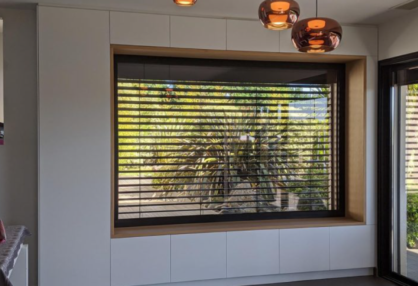 À Montardon, fenêtre avec store à lames orientables intégré à un projet de menuiserie pour la maison